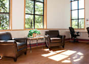 Thumbnail 10 of 14 - Community room with leather chairs and desk chairs