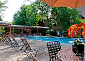Thumbnail 7 of 14 - Outdoor pool with lounge chairs, umbrella tables, and shaded areas
