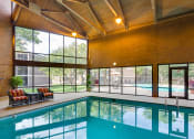 Thumbnail 11 of 25 - Indoor pool with high ceiling and lounge seating