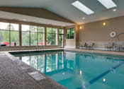 Thumbnail 7 of 17 - Indoor pool with high ceiling and lounge seating