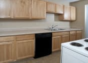 Thumbnail 7 of 19 - kitchen with wood cabinets, black dishwasher, white oven, and a sink