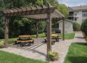 Thumbnail 8 of 21 - Sunny patio with circular park seating and outdoor grills