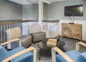 Thumbnail 10 of 23 - Community room with chairs facing a television