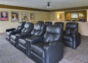 Thumbnail 17 of 23 - Rows of leather chairs and movie posters on the wall of a theater room