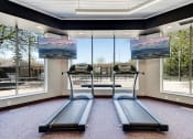 Thumbnail 8 of 23 - Fitness room with treadmills facing TVs and large windows