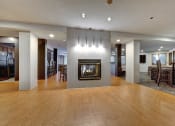 Thumbnail 6 of 26 - Community room with large hardwood floor and a fireplace