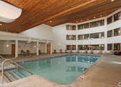 Thumbnail 7 of 26 - Indoor pool with high ceiling and lounge seating