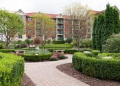 Thumbnail 26 of 27 - Garden with stone footpaths in front of apartment building