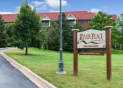 Thumbnail 21 of 27 - Sign next to a road with the words "River Place Apartments"