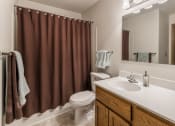 Thumbnail 7 of 19 - Bathroom with white countertop and brown shower curtain