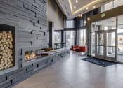 Thumbnail 11 of 42 - Lobby with a pile of logs next to a fireplace and red chairs in the background