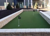Thumbnail 13 of 42 - Outdoor putting green with three holes with small flags in them