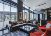 Thumbnail 31 of 42 - Community room with a variety of seating looking towards floor-to-ceiling windows