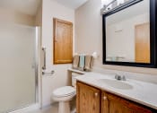 Thumbnail 6 of 26 - Bathroom with wooden cabinets and glass door on the shower