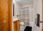 Thumbnail 5 of 26 - Bathroom with wooden cabnets and striped shower curtain