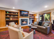 Thumbnail 8 of 26 - Clubroom with conversational seating in front of a fireplace and a TV