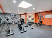Thumbnail 18 of 26 - Fitness room with various equipment and orange walls
