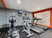 Thumbnail 16 of 26 - Fitness room with treadmils and elipticals facing a TV