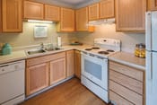 Thumbnail 1 of 12 - kitchen with bright wooden cabinets, white countertops, and white appliances