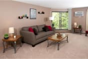 Thumbnail 2 of 12 - Living room with a gray couch and light brown wooden tables