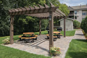 Thumbnail 8 of 12 - Sunny patio with circular park seating and outdoor grills