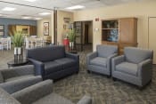 Thumbnail 2 of 17 - community room with gray chairs and sofas