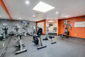 Thumbnail 18 of 27 - Fitness room with various equipment and orange walls