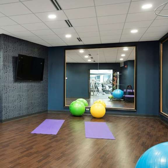 A room with exercise equipment and a mirror.