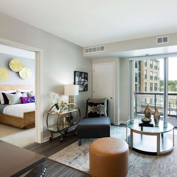 A modern living room with a glass table and a large window.