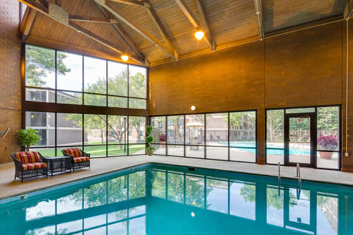 Indoor pool with high ceiling and lounge seating