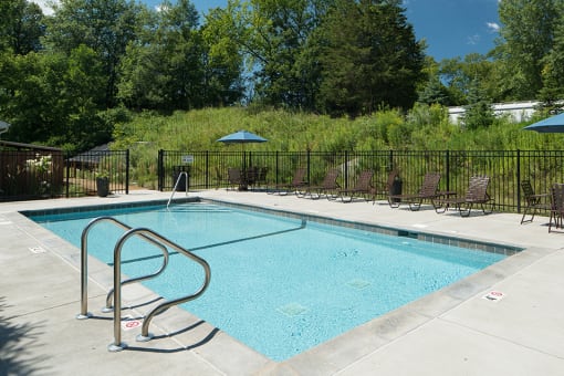 outdoor pool and multiple deck chairs