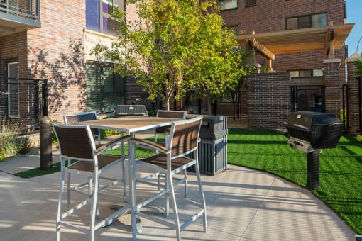 outdoor grilling station with chairs and a table