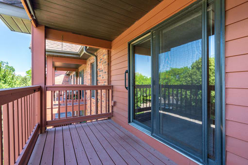 Maroon colored wooden deck and a sliding glass door