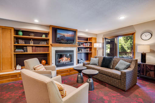 Clubroom with conversational seating in front of a fireplace and a TV