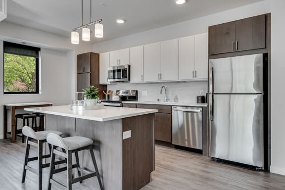 Kitchen with white cabinets, stainless steel appliances, and hanging lights over the island