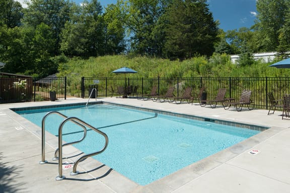 outdoor pool and multiple deck chairs