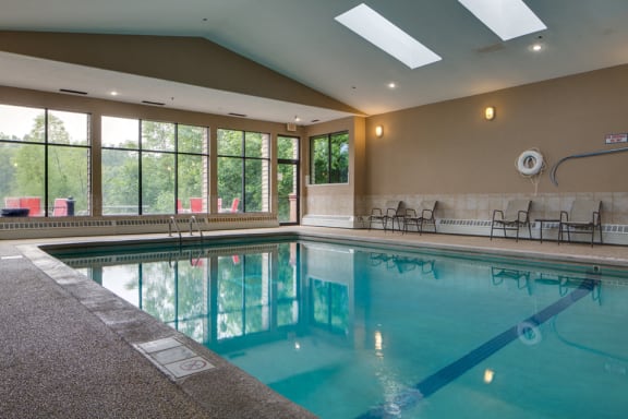 Indoor pool with high ceiling and lounge seating