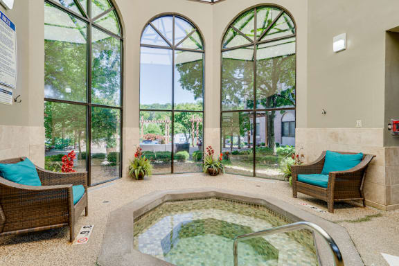 Indoor jacuzzi next to three tall windows