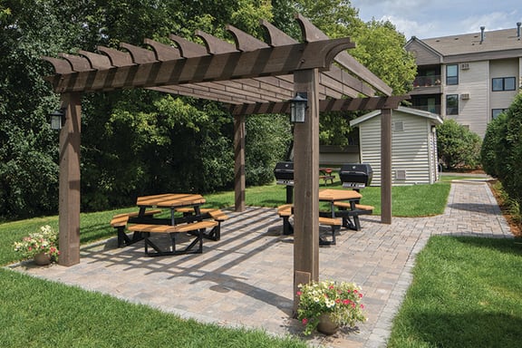 Sunny patio with circular park seating and outdoor grills