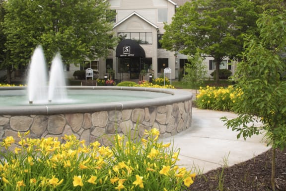 Large water fountain in front of the entrance to the apartment lobby