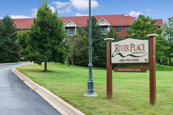 Sign next to a road with the words "River Place Apartments"