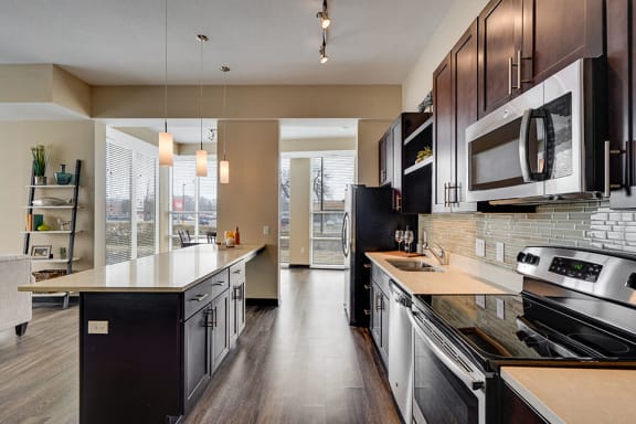 Kitchen with white tabletops, dark brown cabinets, and modern appliances