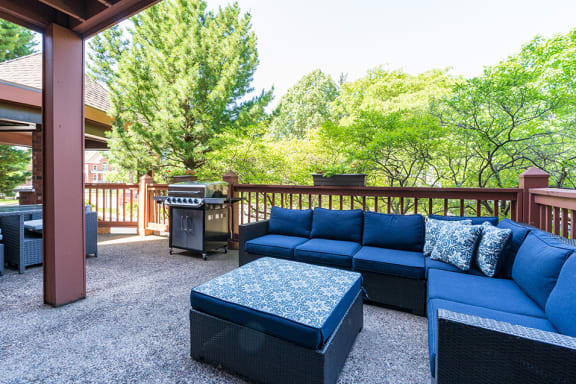Outdoor patio with blue chairs and a grill