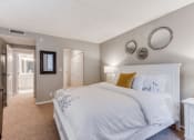 Thumbnail 7 of 25 - Bedroom with white comforters and bathroom and closet in frame