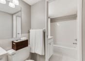 Thumbnail 9 of 25 - White bathroom with bright lights and the camera facing the bathtub and shower