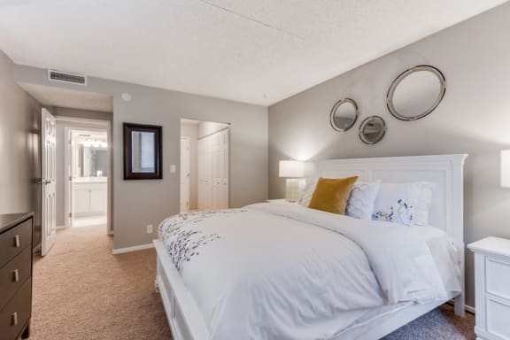Bedroom with white comforters and bathroom and closet in frame