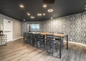 Thumbnail 13 of 22 - Community room with long table and high chairs, and a coffee maker in the corner