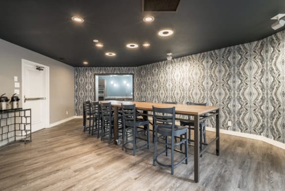 Community room with long table and high chairs, and a coffee maker in the corner