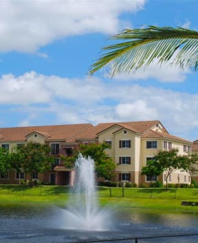 a fountain in a pond in front of an apartment building at Sanctuary Cove, North Lauderdale, 33068