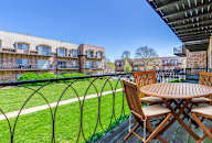 a table and chairs sit on a balcony overlooking a grassy area and apartment buildings at Waldo Heights, Missouri